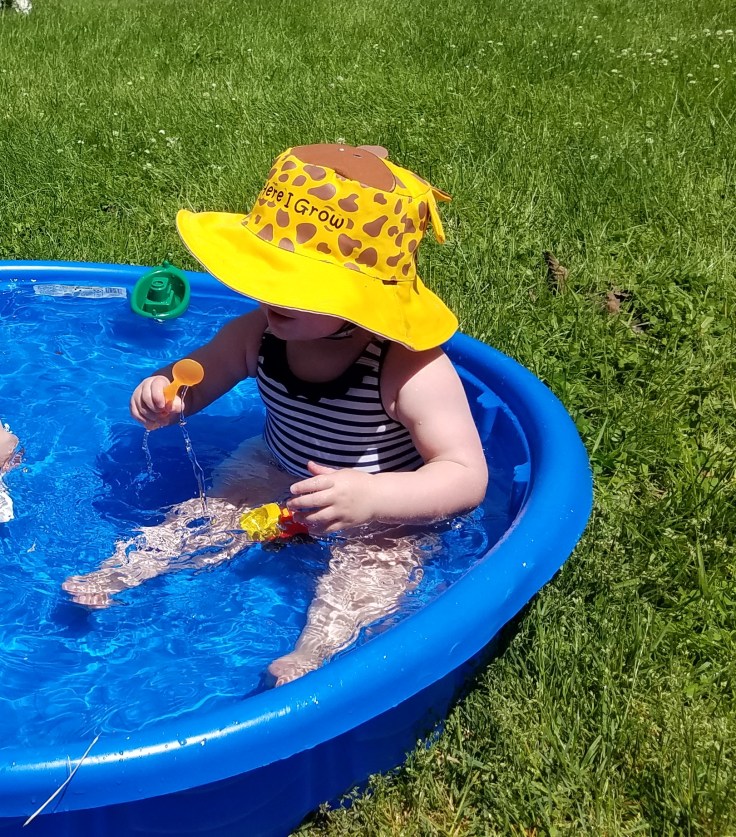 Better Beauty Vermont playing in kiddie pool with giraffe hat
